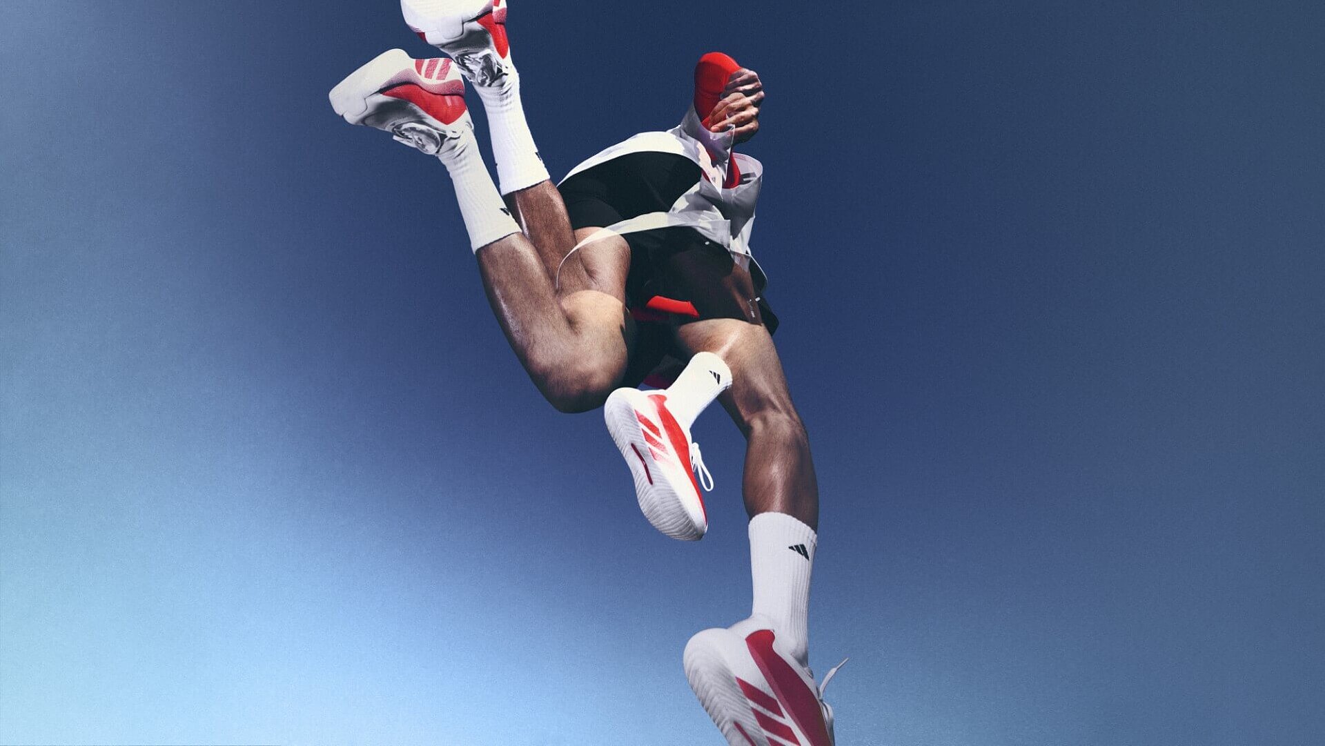 Two superimposed images of a runner, in the style of a multiple exposure. The camera angle is from the ground, looking straight up.