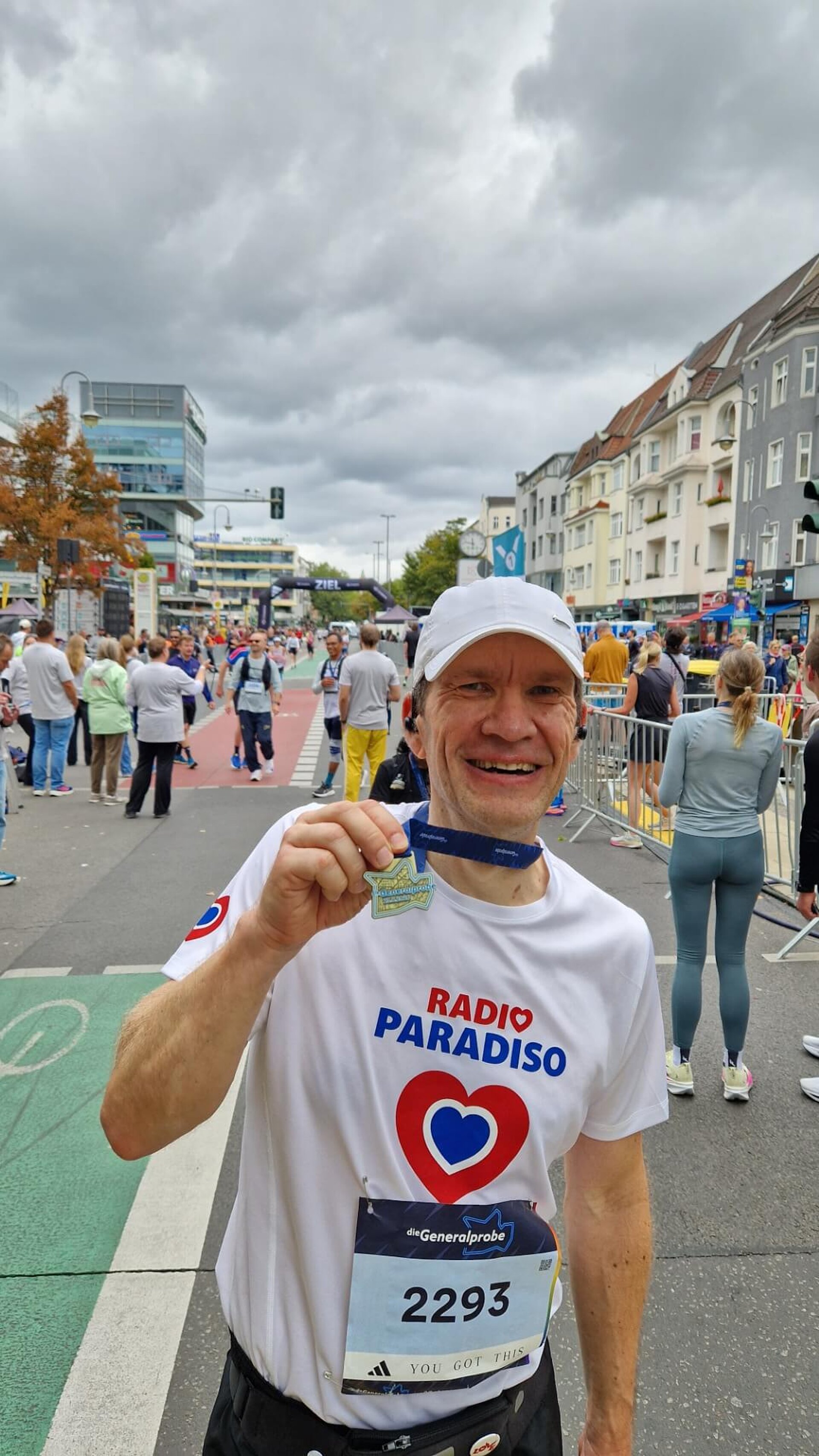 Thorsten hält erschöpft aber glücklich grinsend seine Medaille in die Kamera.