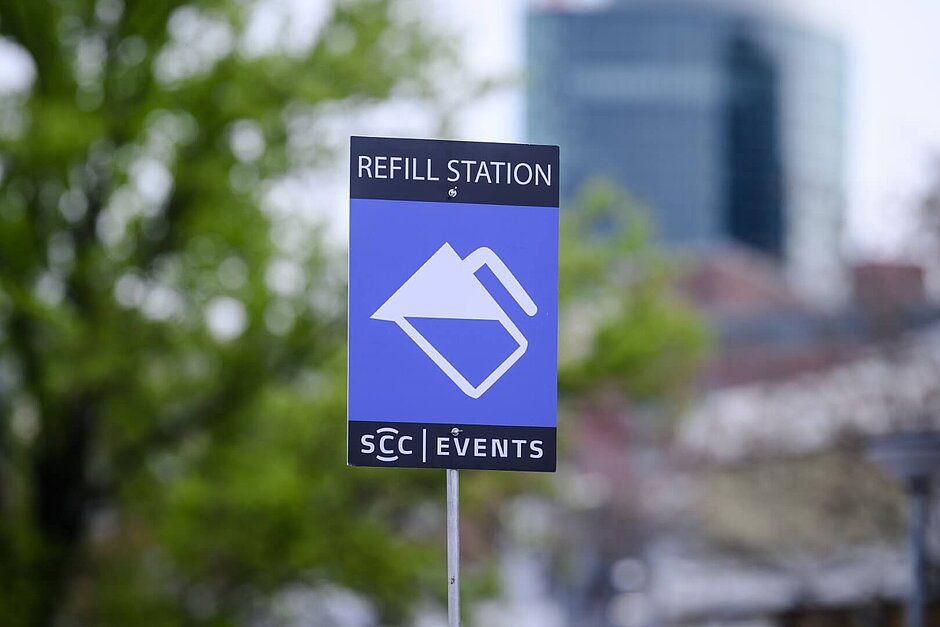 Blaues Schild mit der Aufschrift “REFILL STATION” und einem Icon einer Wasserkaraffe.