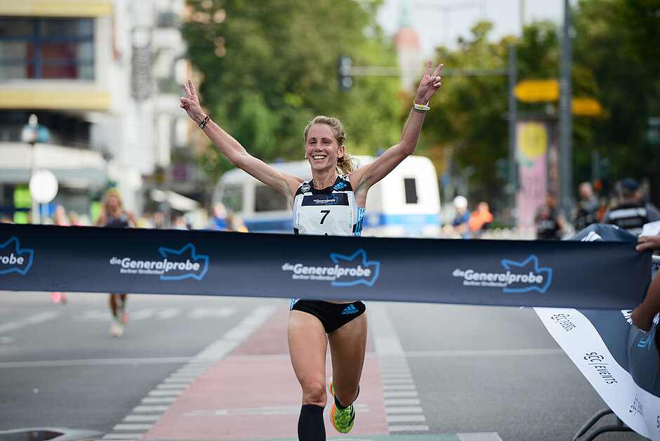 Generalprobe Halbmarathon (2023): Siegerin jubelt im Ziel mit Victoryzeichen © SCC EVENTS / Kai Wiechmann