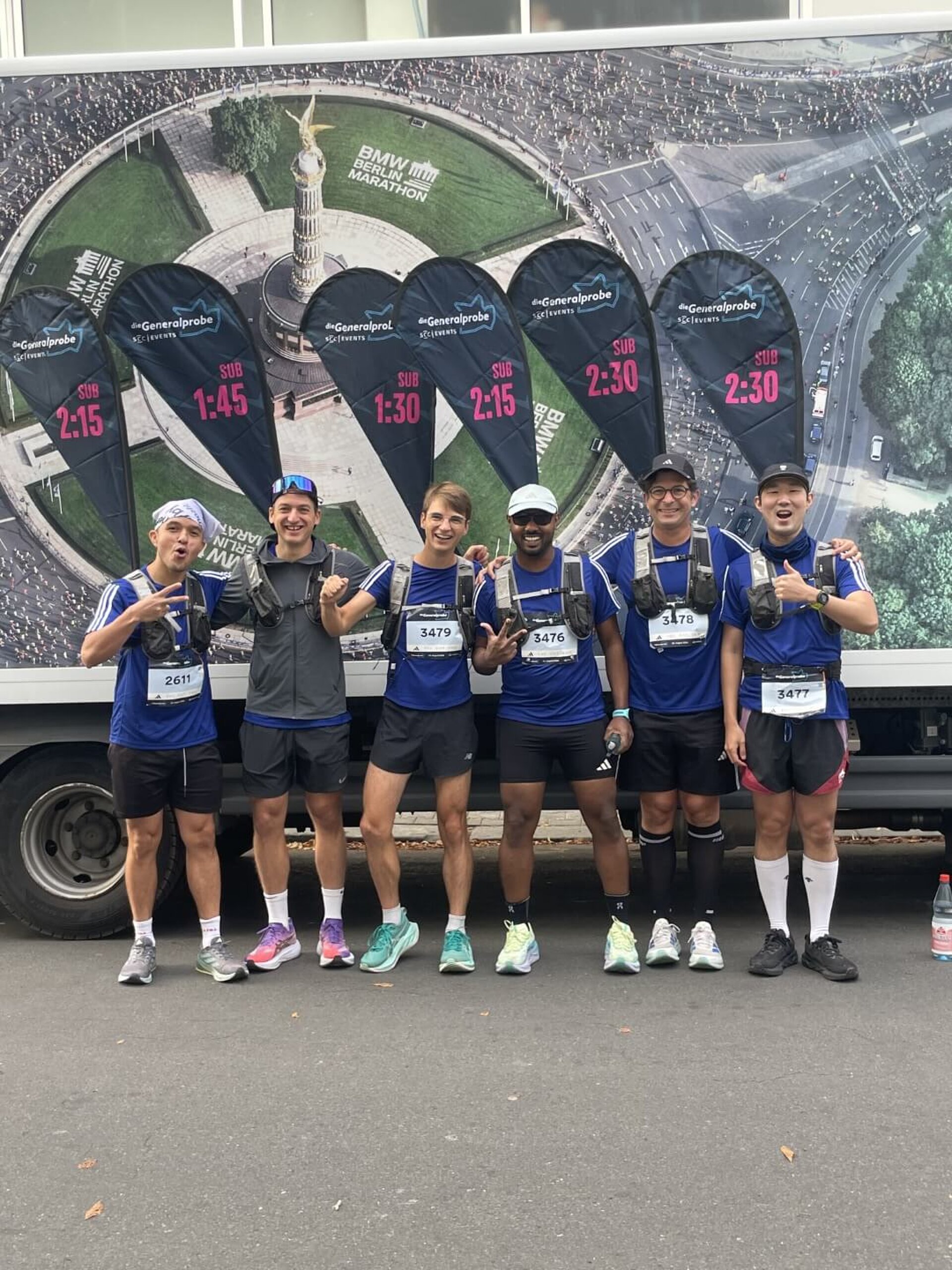 Sechs Pacer mit Zeiten zwischen 2:30 und 1:30 Stunden vor einem LKW von SCC EVENTS.